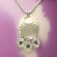 Silver hammered oval shaped necklace with black tourmaline cubic zirconia crystals in a chandelier style necklace with 18” chain 